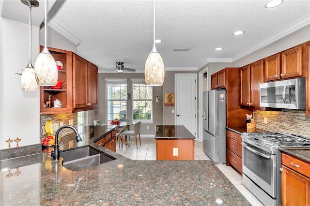 kitchen featuring sink, light tile patterned floors, appliances with stainless steel finishes, hanging light fixtures, and decorative backsplash