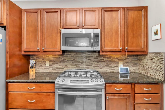 kitchen featuring dark stone countertops, decorative backsplash, and stainless steel appliances