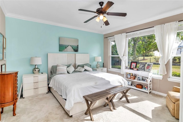 carpeted bedroom featuring crown molding and ceiling fan