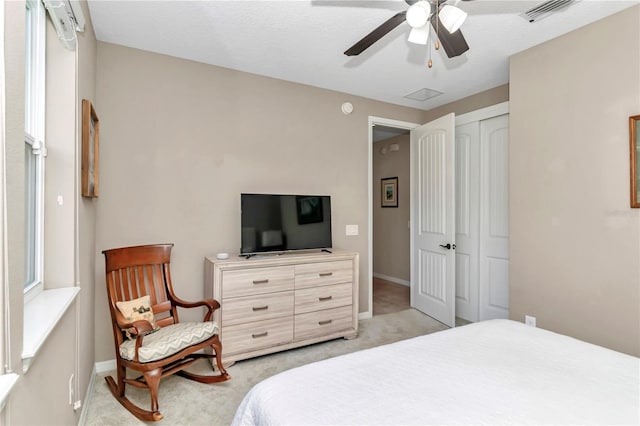 bedroom with light colored carpet, a closet, and ceiling fan