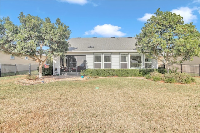 back of property with a sunroom and a yard