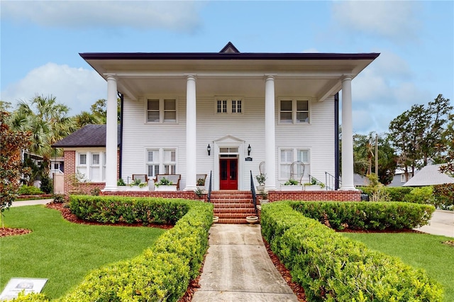 greek revival inspired property featuring a front lawn