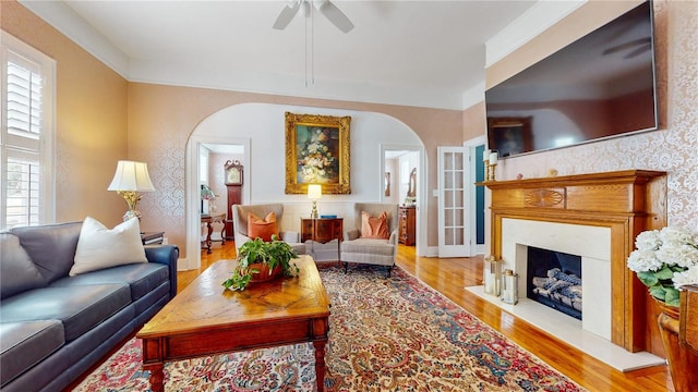 living room featuring ceiling fan, light hardwood / wood-style floors, and crown molding