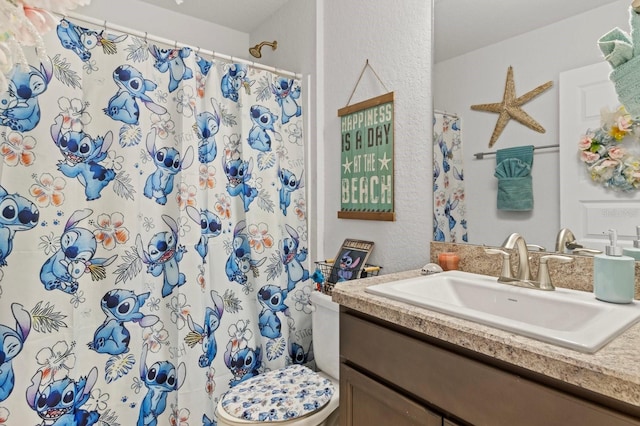 bathroom featuring a shower with curtain, vanity, and toilet