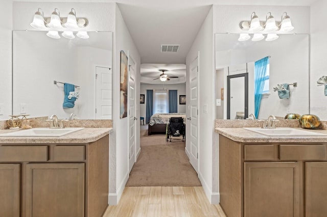 bathroom with hardwood / wood-style floors, vanity, and ceiling fan with notable chandelier