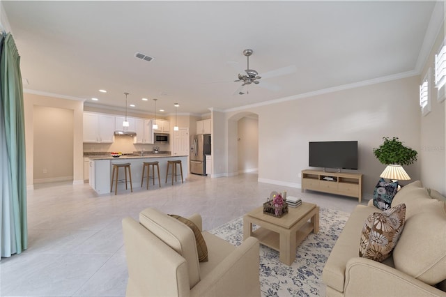 living room with crown molding, light tile patterned floors, and ceiling fan