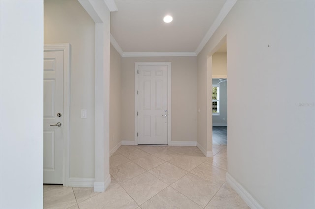 hall with light tile patterned flooring and ornamental molding