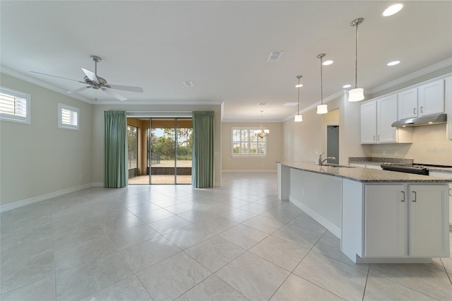 kitchen with light stone counters, white cabinets, ceiling fan with notable chandelier, and ornamental molding