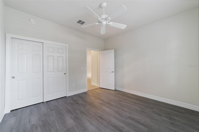 unfurnished bedroom with ceiling fan, a closet, and dark hardwood / wood-style floors