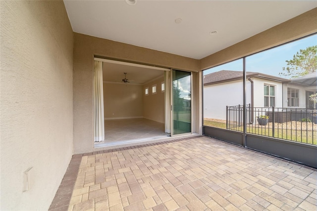 unfurnished sunroom featuring ceiling fan