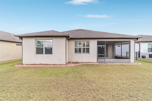 rear view of property featuring a sunroom and a yard