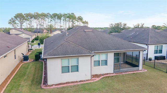 rear view of property with central AC, a lawn, and a sunroom