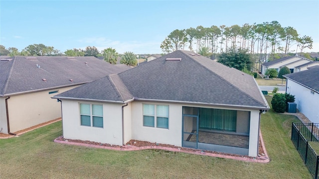 rear view of property with a yard and central AC unit