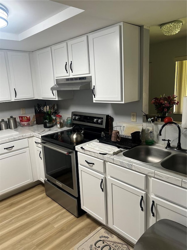 kitchen with sink, white cabinetry, and stainless steel range with electric cooktop