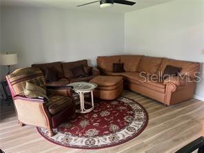 living room with ceiling fan and hardwood / wood-style flooring