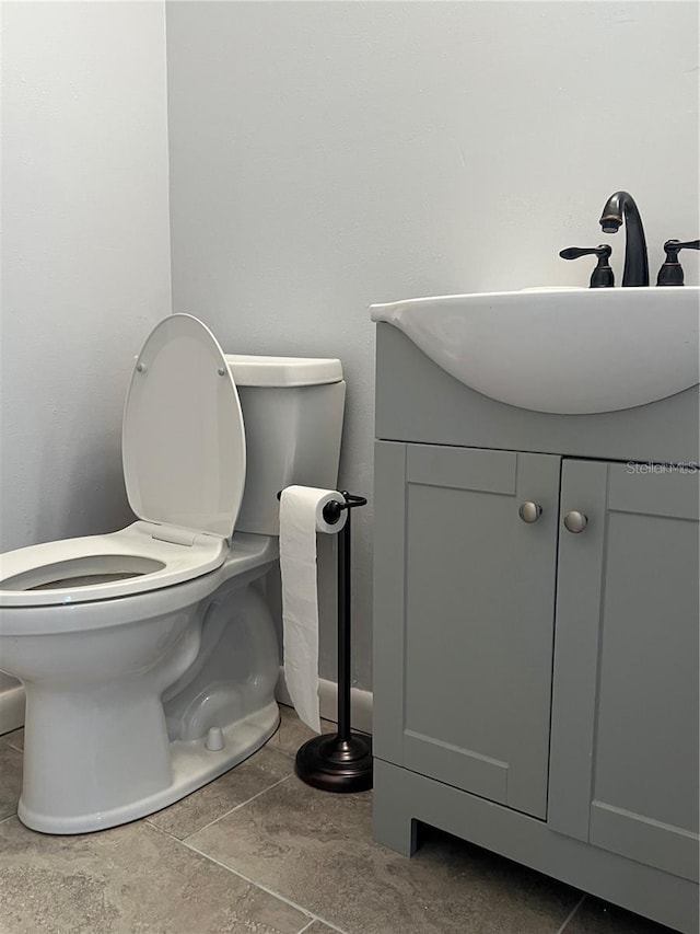 bathroom with tile patterned flooring, vanity, and toilet