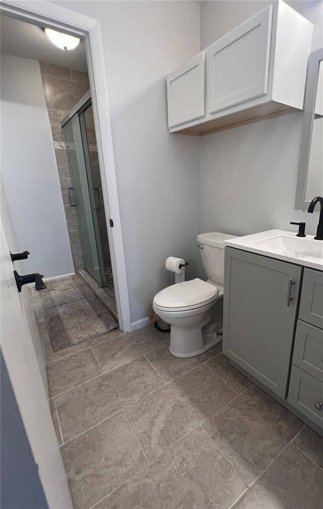 bathroom featuring vanity, toilet, and an enclosed shower