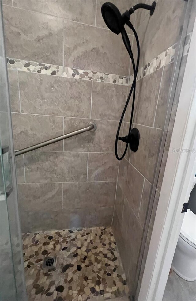 bathroom with toilet and a shower with shower door