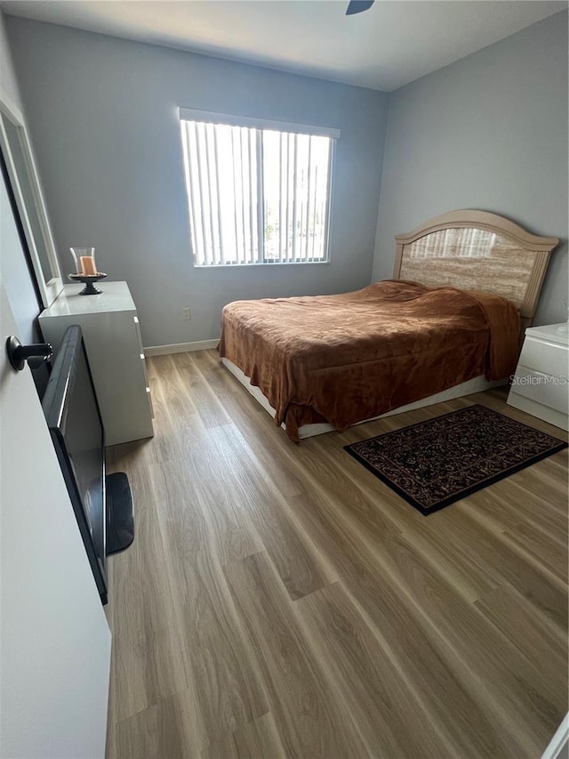 bedroom with light hardwood / wood-style floors, ceiling fan, and billiards