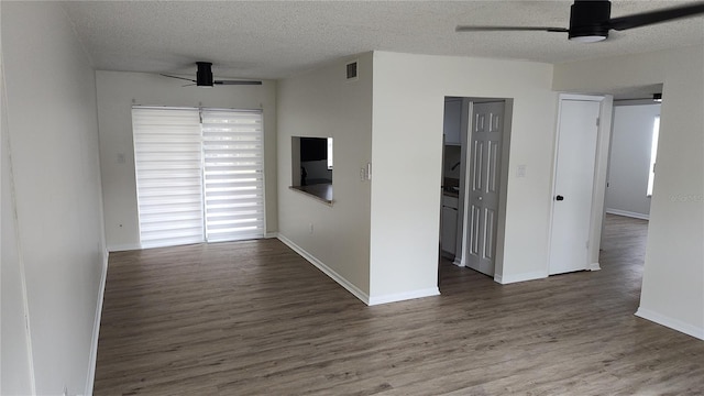 empty room featuring a textured ceiling, dark hardwood / wood-style flooring, and ceiling fan