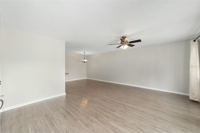 unfurnished room featuring hardwood / wood-style floors, ceiling fan with notable chandelier, and a textured ceiling