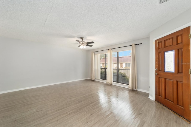 entrance foyer featuring plenty of natural light, wood-type flooring, and a textured ceiling