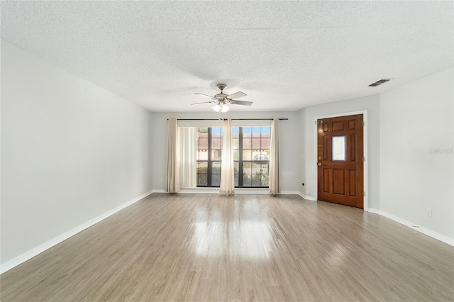 interior space with a textured ceiling, light hardwood / wood-style floors, and ceiling fan