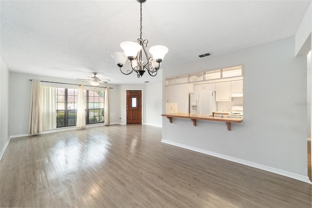 unfurnished living room featuring a textured ceiling, dark wood-type flooring, and ceiling fan with notable chandelier