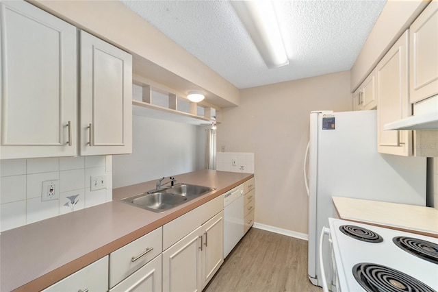 kitchen with sink, white cabinets, white appliances, and light hardwood / wood-style flooring