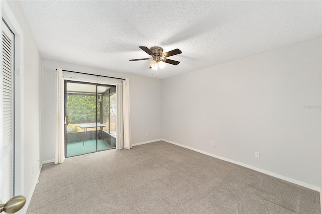 carpeted empty room featuring ceiling fan and a textured ceiling