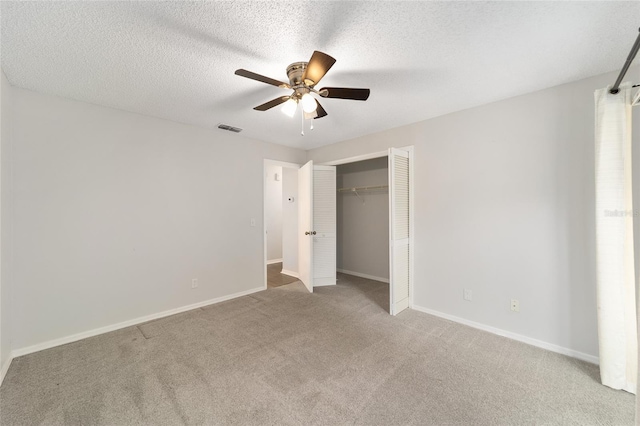 unfurnished bedroom with carpet, ceiling fan, and a textured ceiling