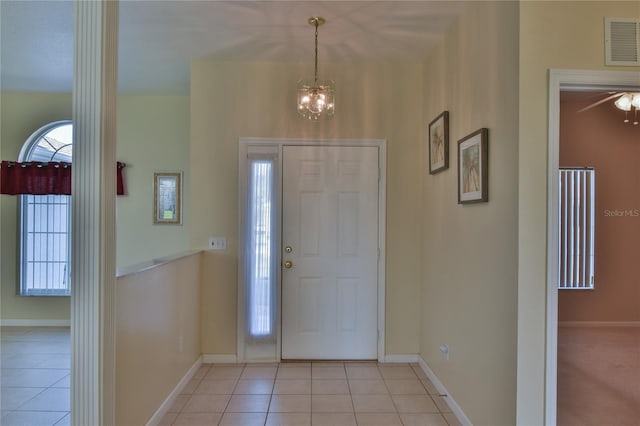 tiled foyer with an inviting chandelier