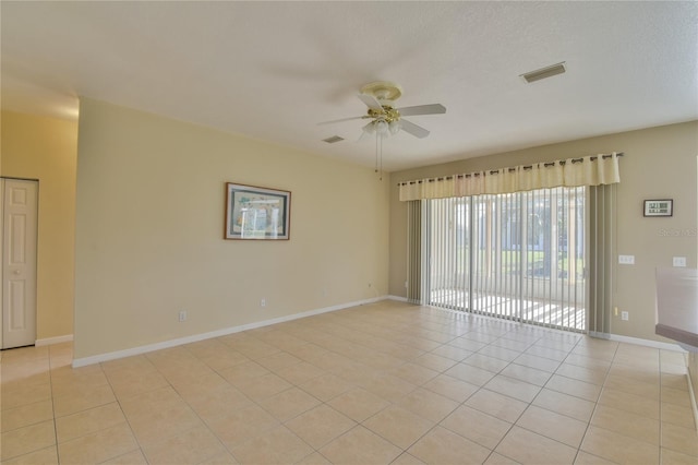 tiled spare room featuring ceiling fan