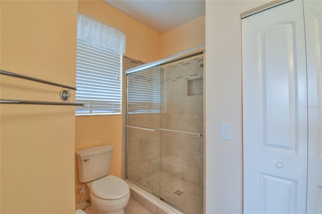 bathroom with tile patterned floors, toilet, and an enclosed shower