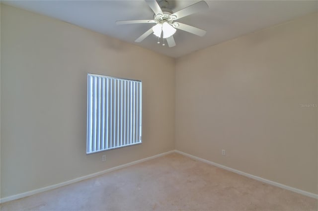 spare room featuring light carpet and ceiling fan