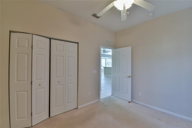 unfurnished bedroom with ceiling fan, a closet, and light colored carpet