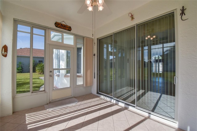 doorway to outside with ceiling fan and light tile patterned flooring