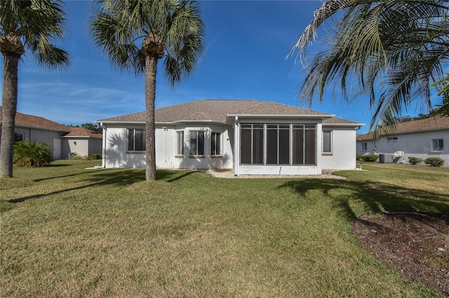 rear view of property with a sunroom and a yard