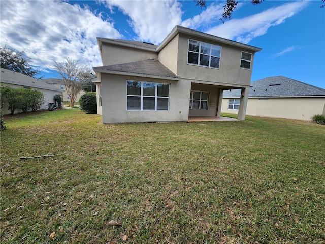 back of property featuring a patio area and a lawn