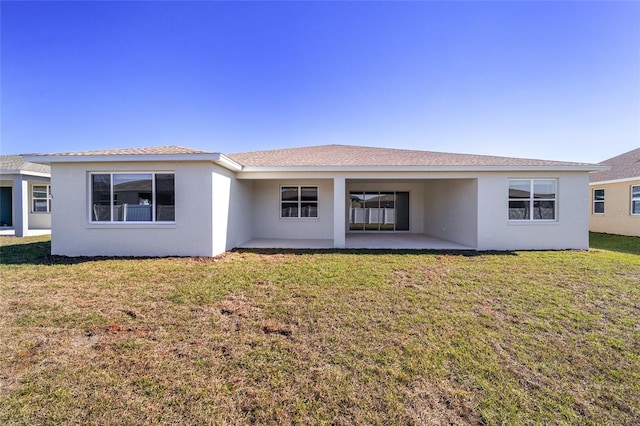 rear view of house featuring a patio and a lawn