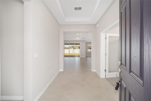 hallway with a raised ceiling