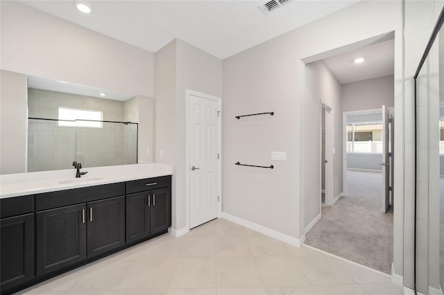 bathroom featuring tile patterned flooring, vanity, and walk in shower