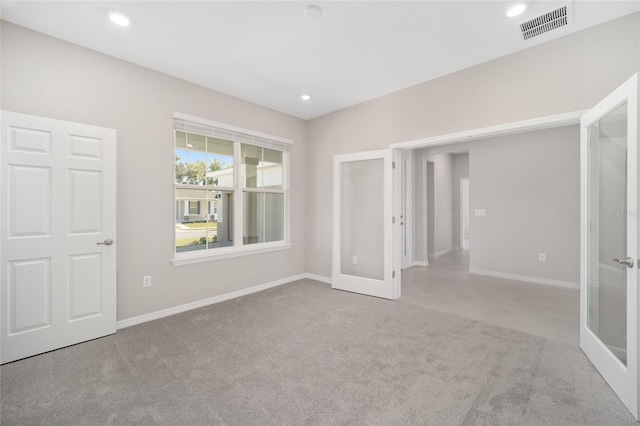 carpeted spare room with french doors