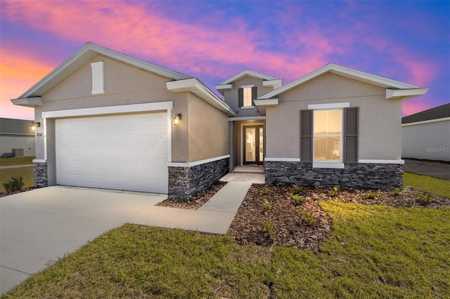 view of front of property featuring a garage and a lawn