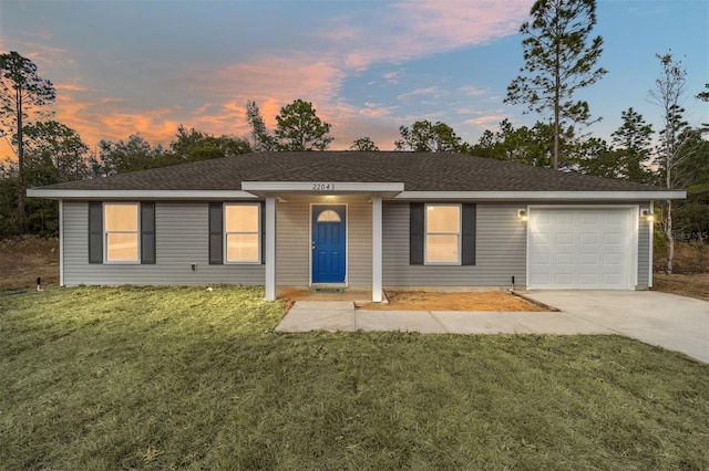 single story home featuring a yard and a garage