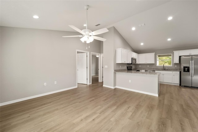 kitchen featuring white cabinets, light hardwood / wood-style floors, kitchen peninsula, and appliances with stainless steel finishes