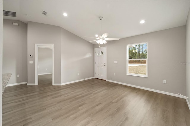 empty room featuring wood-type flooring, ceiling fan, and lofted ceiling