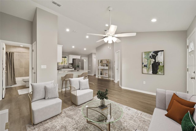 living room featuring ceiling fan, high vaulted ceiling, and wood-type flooring