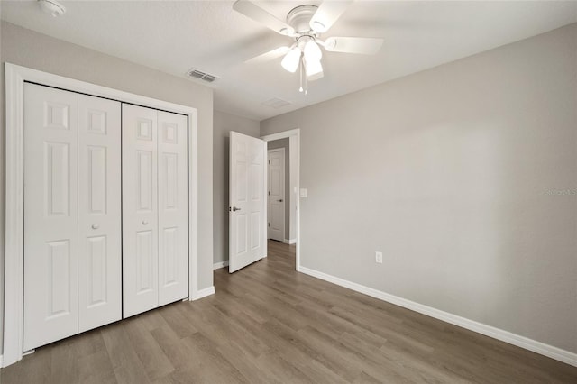 unfurnished bedroom with a closet, light hardwood / wood-style flooring, and ceiling fan