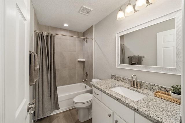 full bathroom with vanity, shower / tub combo, wood-type flooring, and a textured ceiling